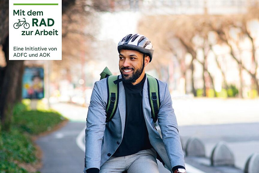 Mit dem Rad zur Arbeit 2022 Mann mit Helm auf Fahrrad und Kampagnenlogos von Mit dem Rad zur Arbeit.