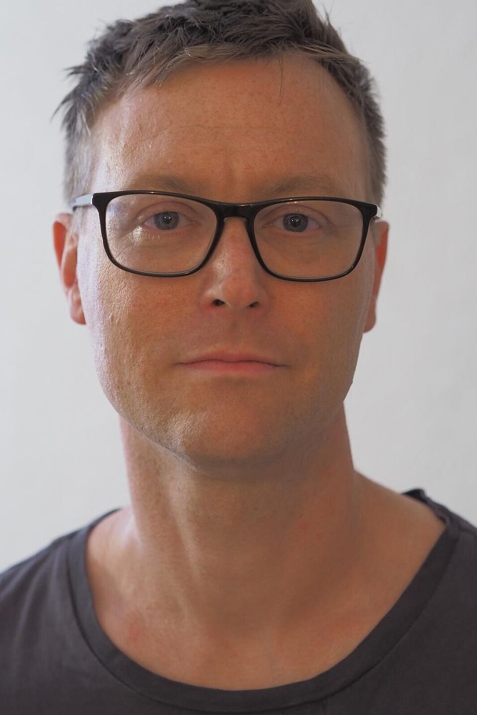 Dr. Rul von Stülpnagel  Porträtfoto von Dr. Rul von Stülpnagel: Mann mit kurzen braunen Haaren, schwarzer Brille und grauem T-Shirt vor weißem Hintergrund.