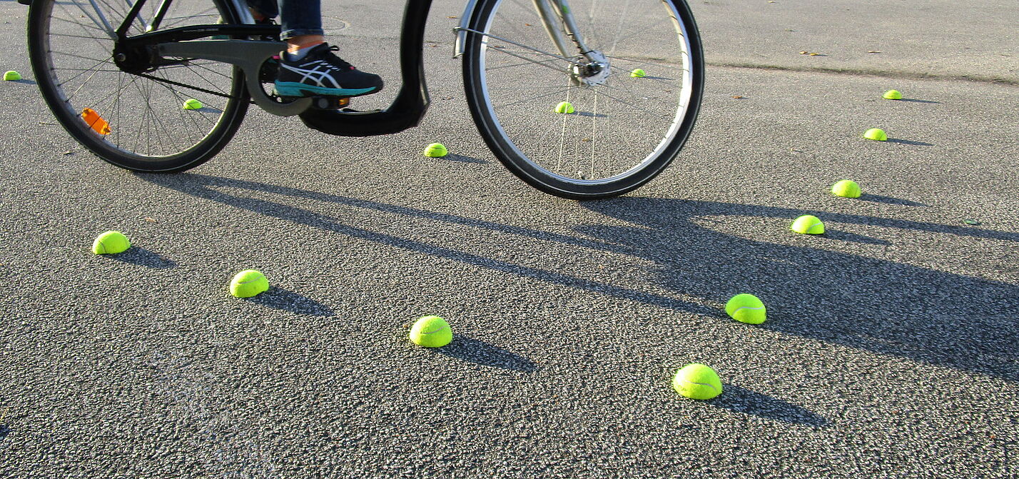 Fahrradparcour mit geteilten Tennisbällen und Radfahrer